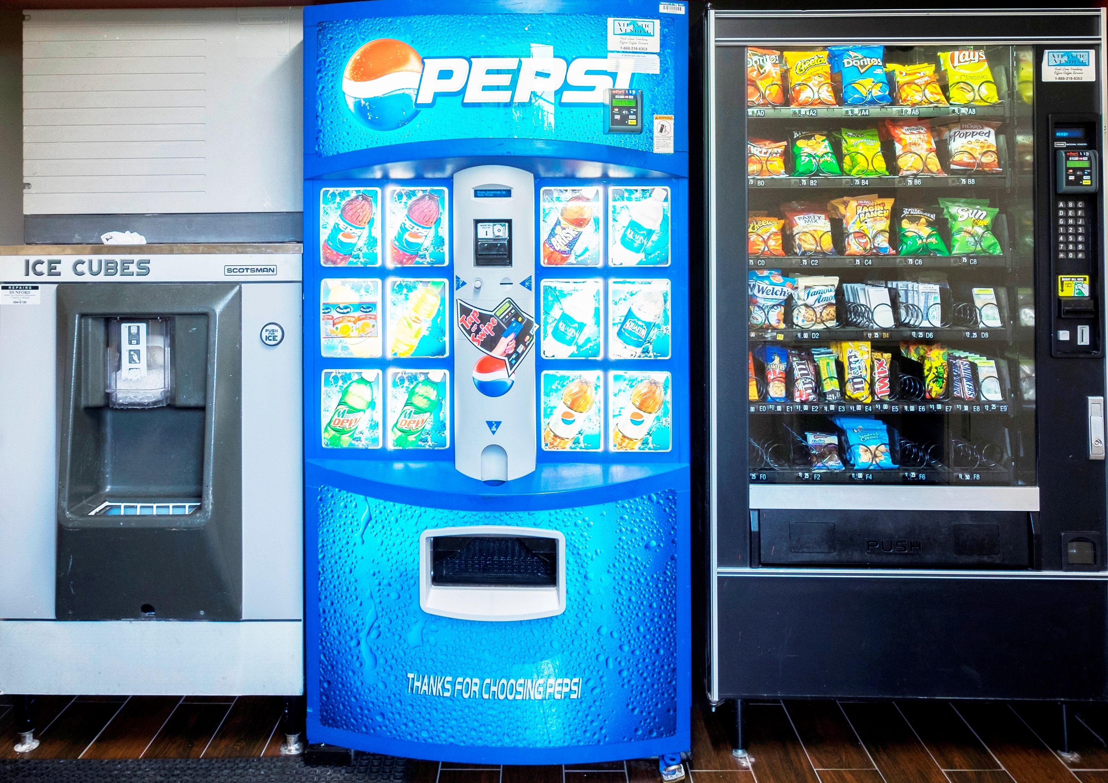 A vending machine with various snacks and drinks, including Pepsi, and a water dispenser labeled 'Ice Cubes'.