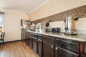 Una cocina con una encimera amplia, varios electrodomésticos y armarios.
