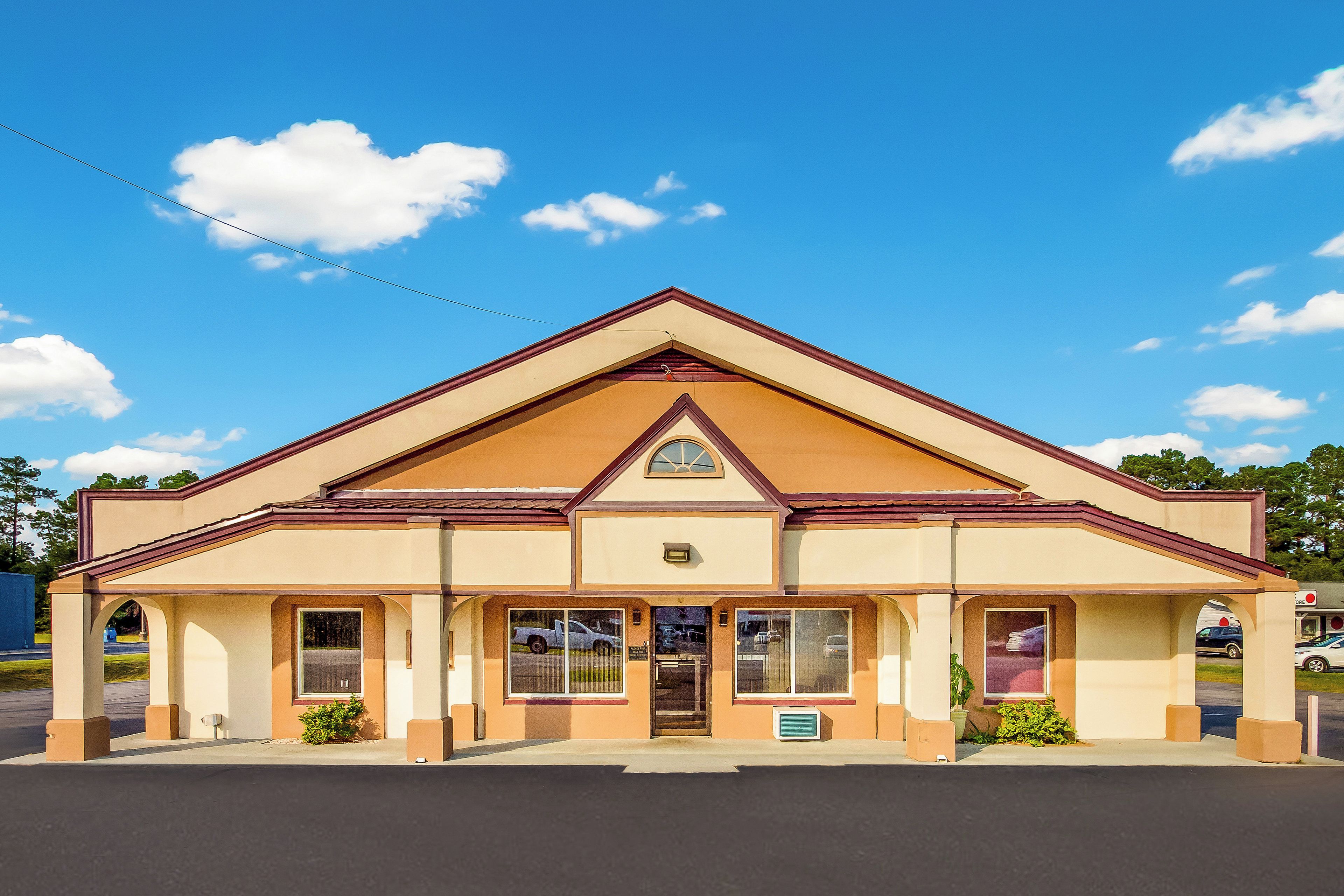 A single-story building with a gabled roof, a central entrance, and a small porch area.