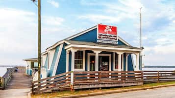 A small, single-story building with a blue exterior and a sign that reads 'Cypress Landing State Park.'