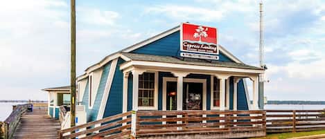 A small, single-story building with a blue exterior and a sign that reads 'Cypress Landing State Park.'