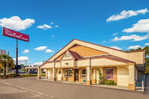 A single-story building with a flat roof and a prominent red sign on the left. - Red Roof Inn Santee (Santee)