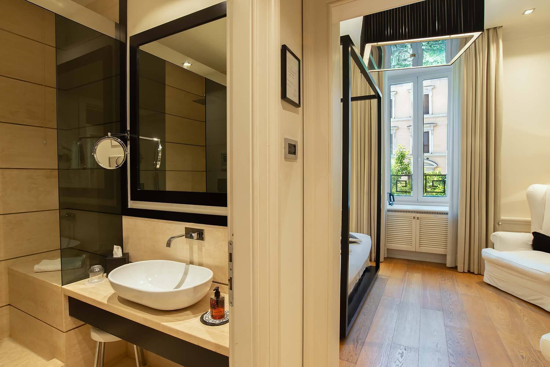 Une salle de bain moderne avec un grand miroir, un lavabo blanc et une cabine de douche en verre.
