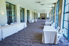A long corridor with tables and chairs, large windows, and a fireplace. - Orange Tree Resort (Scottsdale)