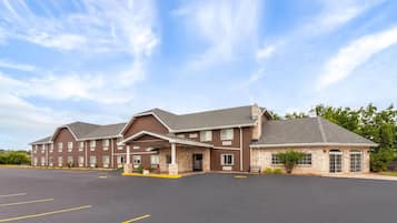 A multi-story hotel with a brick facade and a large parking lot.