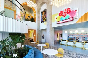 A modern interior with a bar area, seating, and a large neon sign.