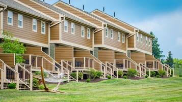 A multi-story residential building with a uniform exterior, multiple balconies, and a well-maintained lawn.