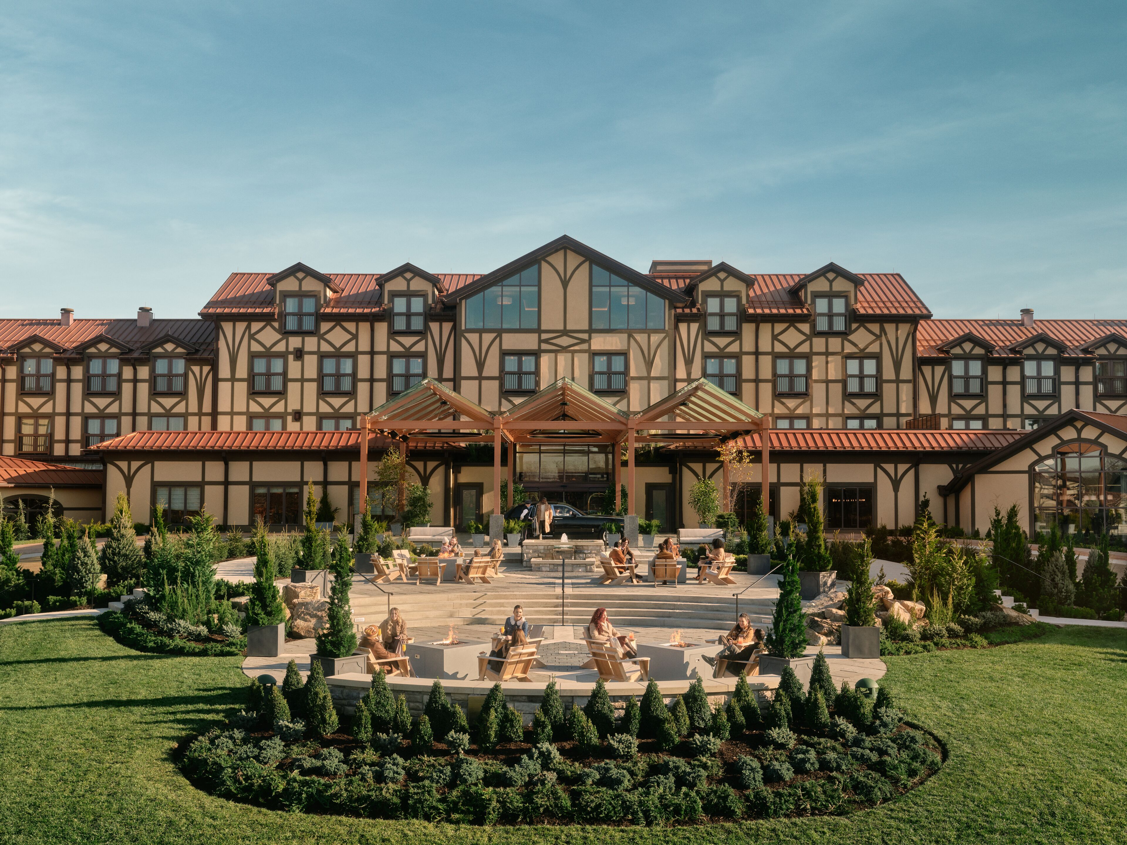 A large hotel with a symmetrical facade, multiple balconies, and a central courtyard with seating and greenery.