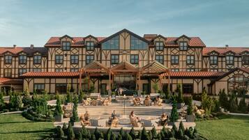 A large hotel with a symmetrical facade, multiple balconies, and a central courtyard with seating and greenery.