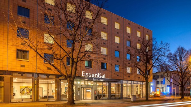Un hôtel à la façade moderne, doté de grandes baies vitrées et d’une enseigne indiquant « Essential by Dorint ».
