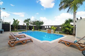 A swimming pool with lounge chairs and palm trees. - Holiday Inn Reynosa Industrial Poniente by IHG (Reynosa)