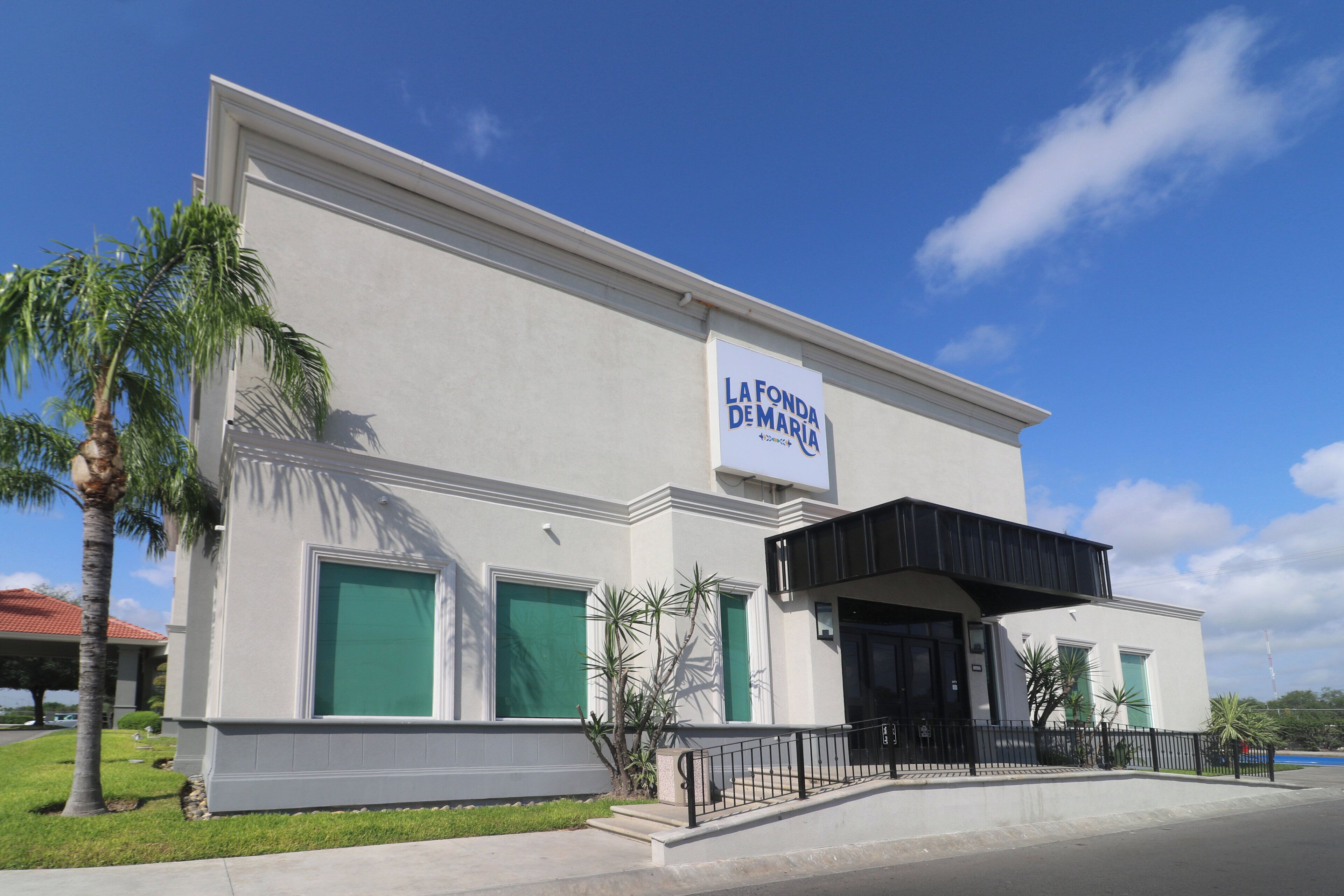 A building with a sign reading 'LA FONDA DE MARIA' and a covered entrance.