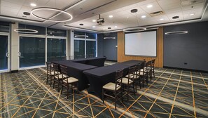 A conference room with a large table, chairs, a projector, and a screen. - Holiday Inn Reynosa Industrial Poniente by IHG (Reynosa)