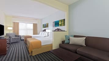Una habitación de hotel con una cama, un sofá, un televisor, un escritorio y una silla.