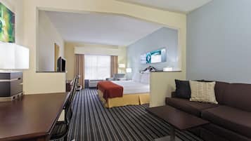 A hotel room with a bed, a sofa, a TV, and a desk.