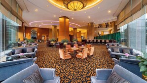 A spacious lobby with a patterned carpet, comfortable seating areas, and a large chandelier. - Hilton Chongqing Hotel (Chongqing)