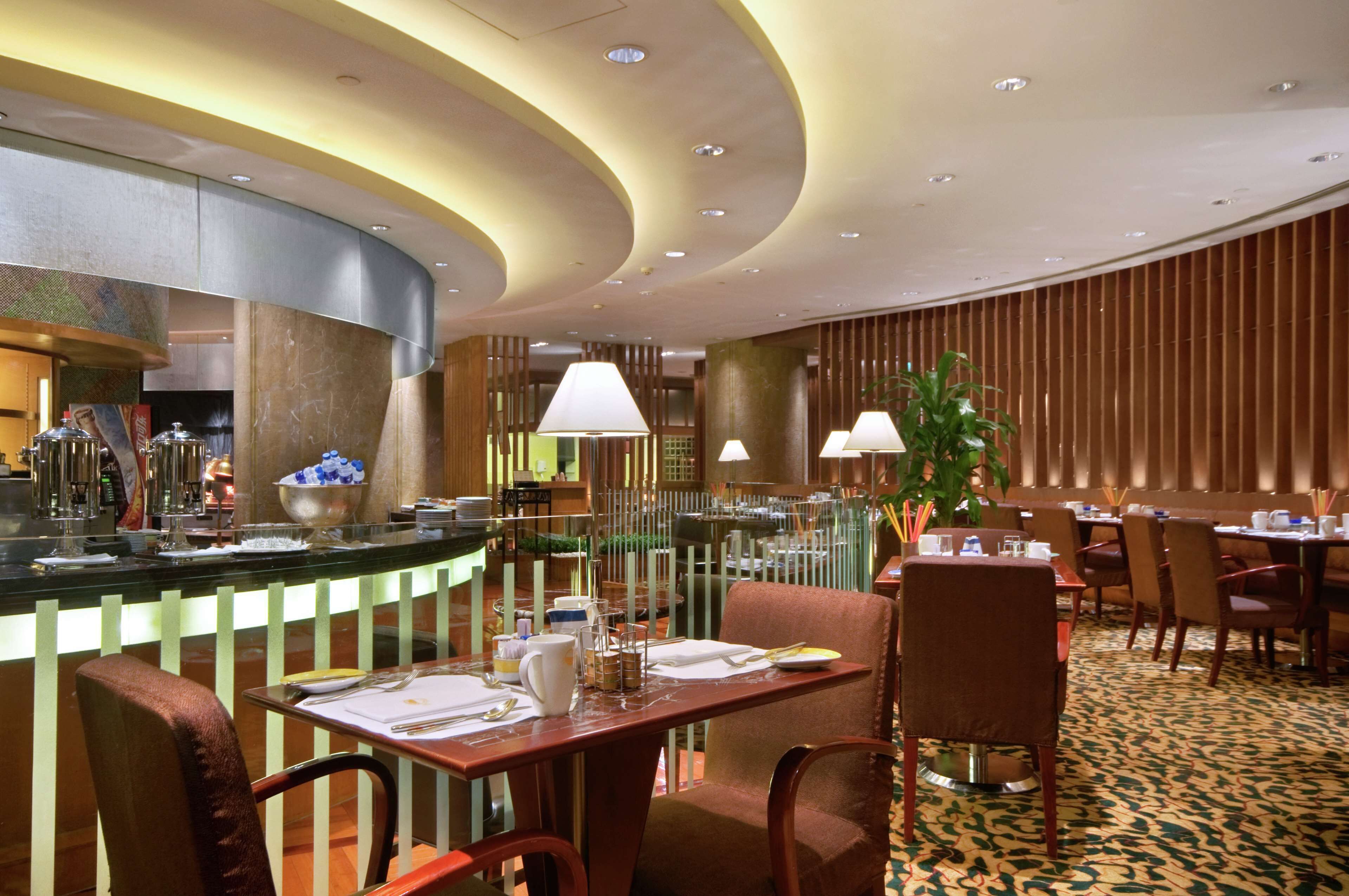 A restaurant with a curved ceiling, a bar area with a counter, and several dining tables and chairs.