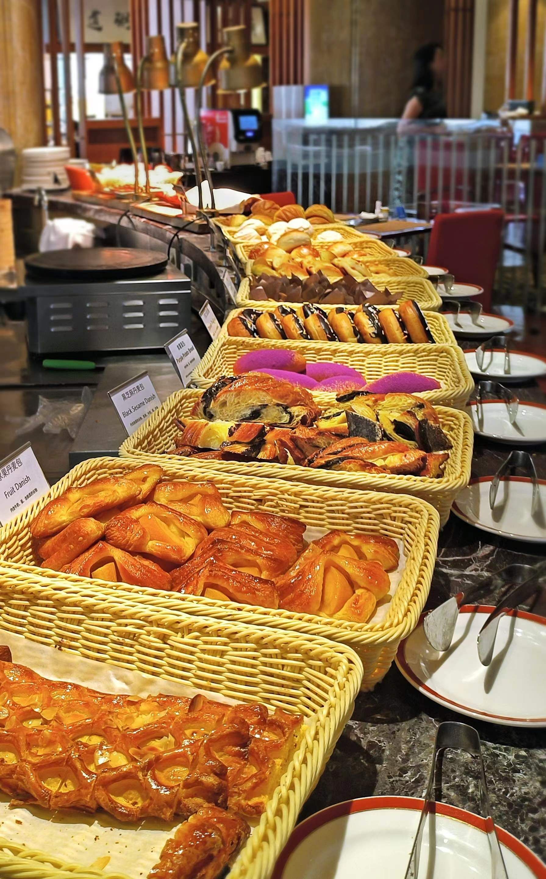 A buffet with various food items displayed in wicker baskets.