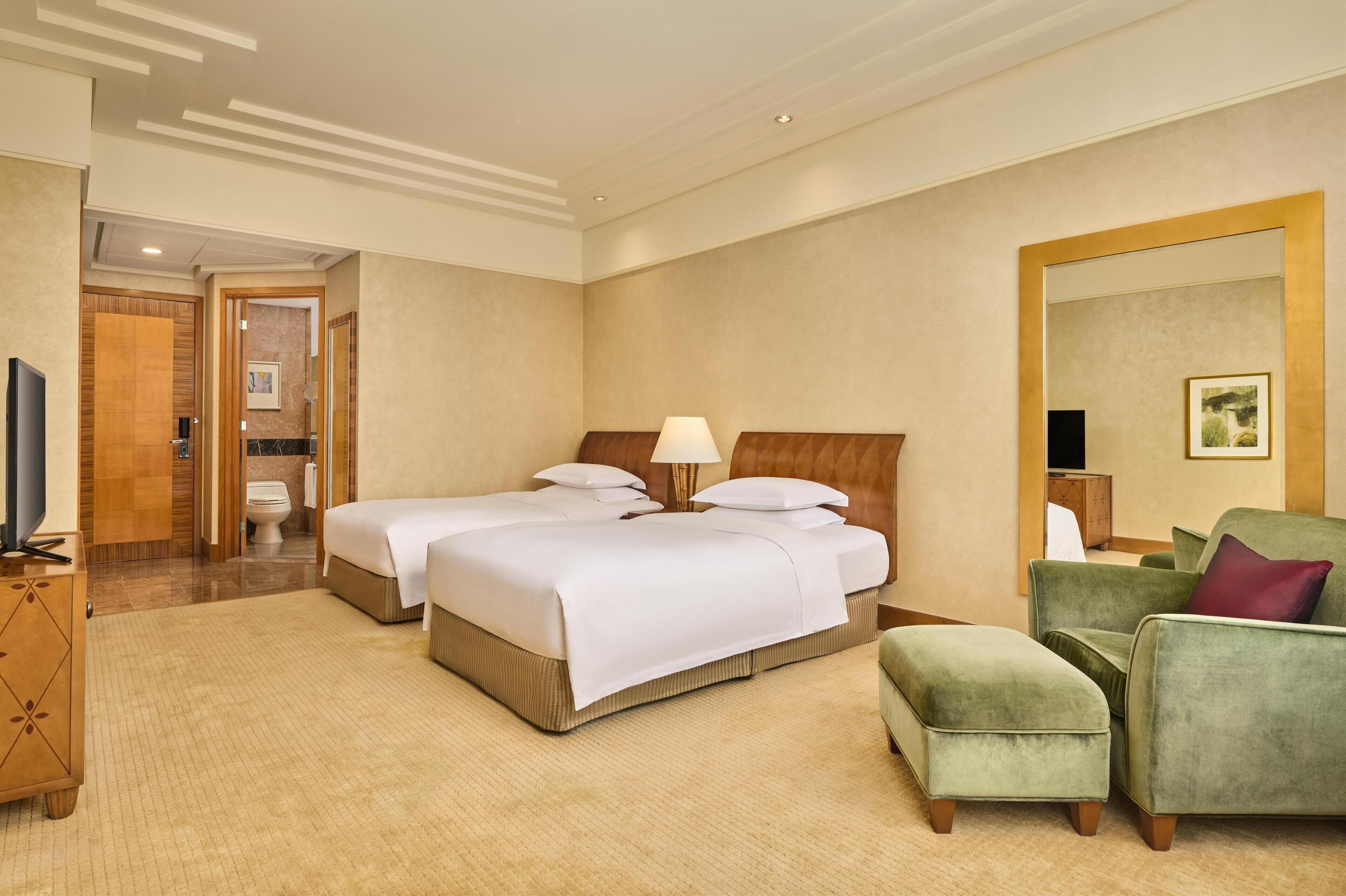 Deluxe kamer | Luxe beddengoed, een minibar, een kluis op de kamer, een bureau