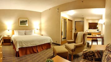 A hotel room with a bed, a desk, a chair, and a bathroom visible through an open door.