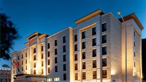 Un hotel de varios pisos con fachada de piedra, numerosas ventanas y un cartel que dice 'Humphry Inn & Suites'.