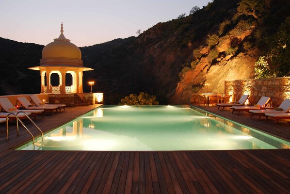 Una piscina al aire libre, tumbonas