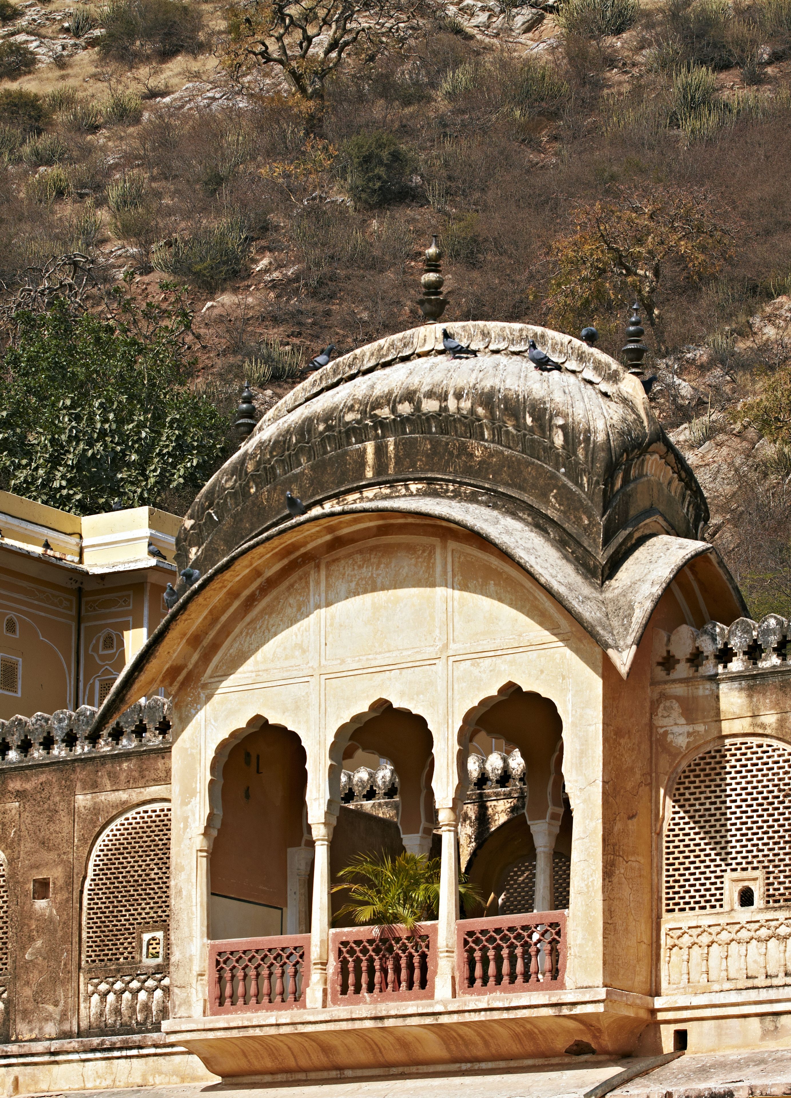 A traditional arched structure with a balcony, featuring intricate lattice work and a decorative finial on top.