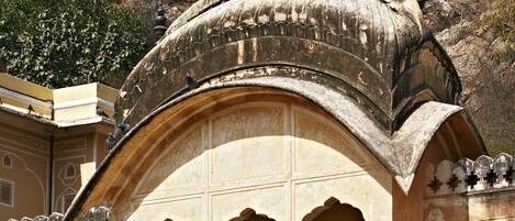 A traditional arched structure with a balcony, featuring intricate lattice work and a decorative finial on top.