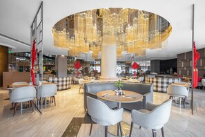 A modern hotel lobby with a central seating area, a bar, and a reception desk. - Ramada Plaza Pudong (Shanghai)