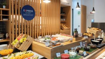 A buffet breakfast area with a variety of fruits, vegetables, and breakfast items.