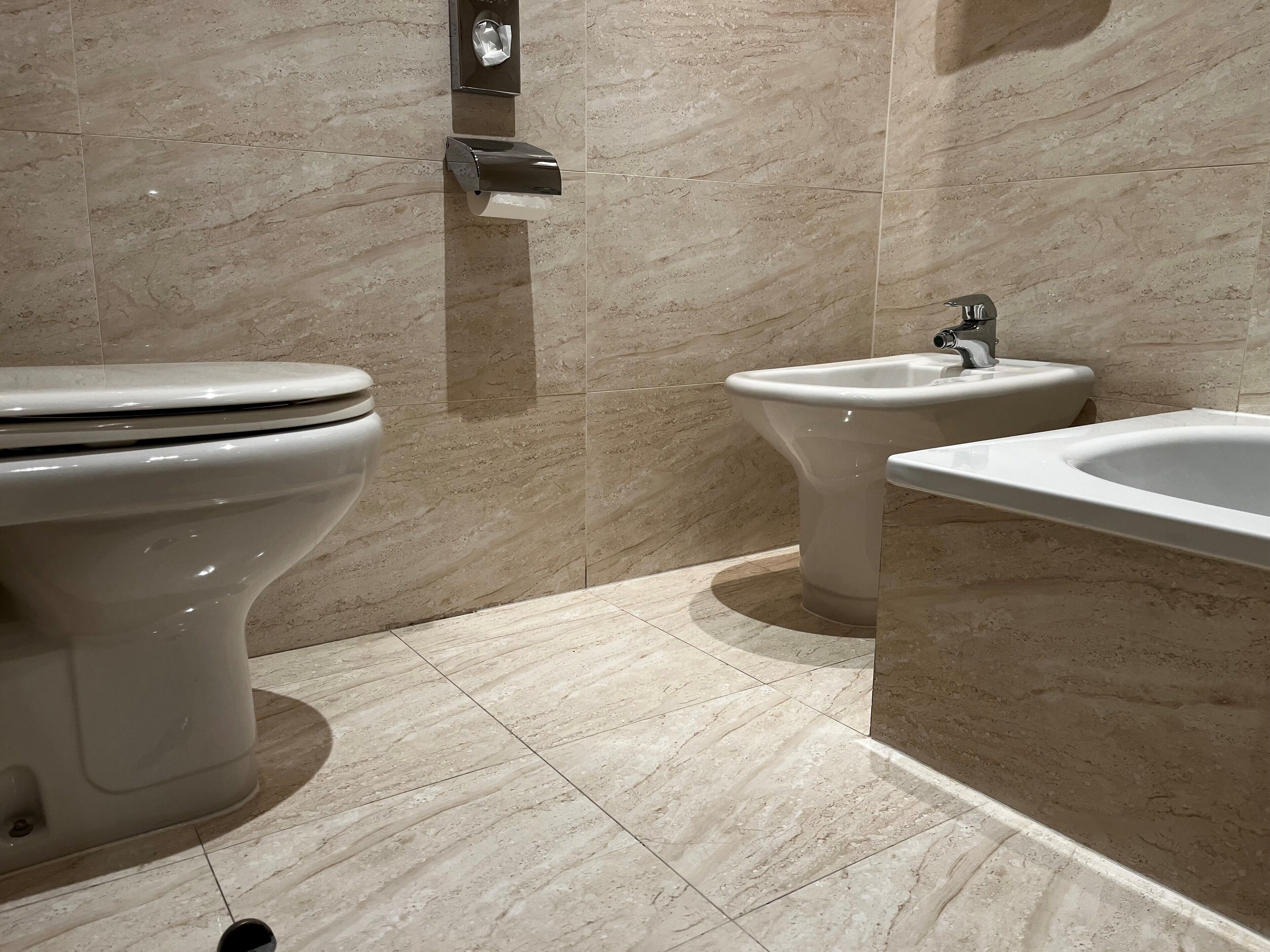 A modern bathroom with a toilet, bidet, and sink.