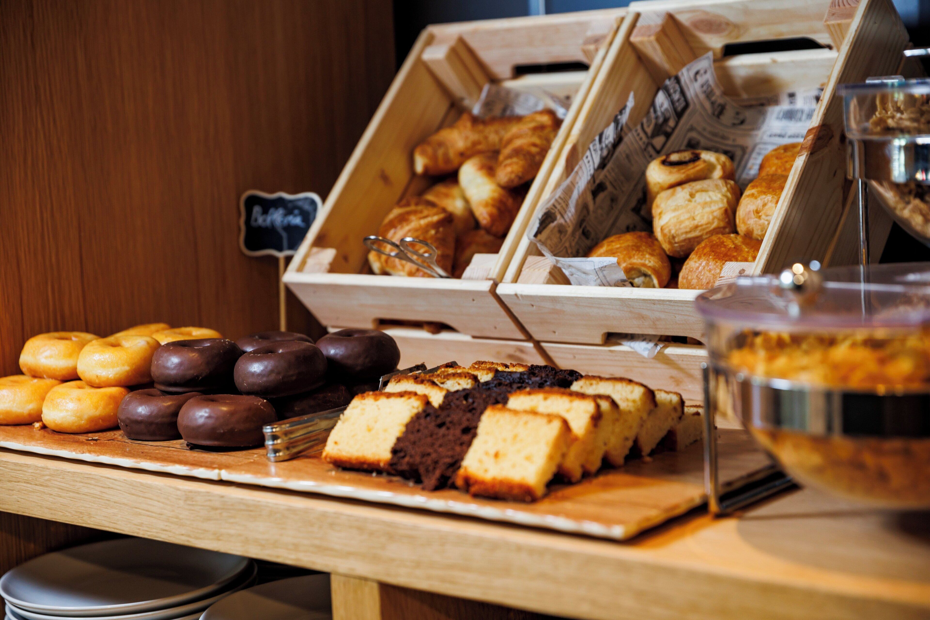 Mostrador de panadería con diversos pasteles y un letrero que dice 'Bakery'.