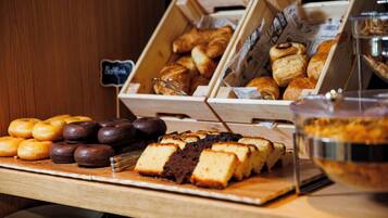 Mostrador de panadería con diversos pasteles y un letrero que dice 'Bakery'.