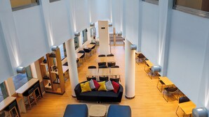 A spacious library with multiple tables and chairs, high ceilings, and large windows. - Holiday Inn Express Logrono Rioja by IHG (Logroño)