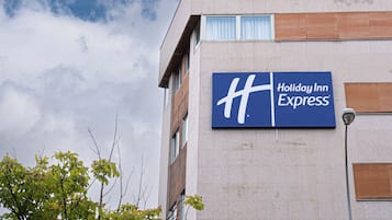 Un letrero de Holiday Inn Express en un edificio, con cielo despejado y algunas nubes.