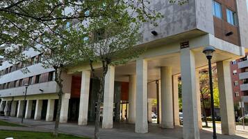A modern building with a covered entrance, large columns, and a sign indicating 'Porte San Miguel.'