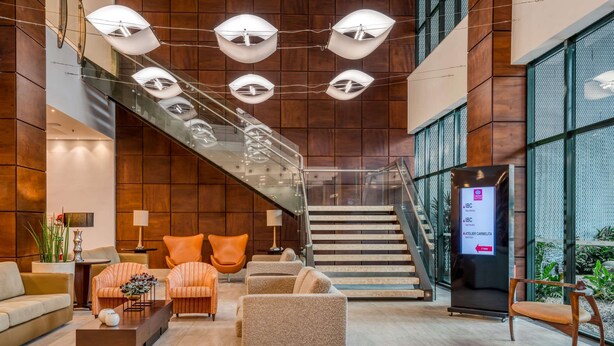 A modern lobby with a staircase, seating area, and a reception desk. - Comfort Suites Vitoria (Vitoria)