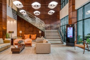 A modern lobby with a staircase, seating area, and a reception desk. - Comfort Suites Vitoria (Vitoria)