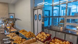 A buffet with various food items including bread, pastries, and desserts. - Comfort Suites Vitoria (Vitoria)