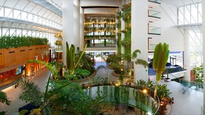 A multi-level atrium with indoor plants, a central walkway, and a glass ceiling. - Melia Benidorm (Benidorm)