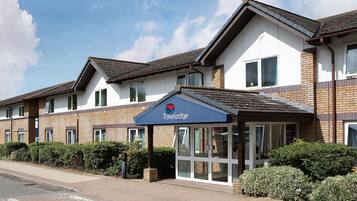 Ein Travelodge Hotel mit überdachter Eingangspartei, Backsteinfassade und zahlreichen Fenstern.