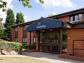 Un hôtel Travelodge avec une façade en briques, de grandes fenêtres et une entrée abritée.
