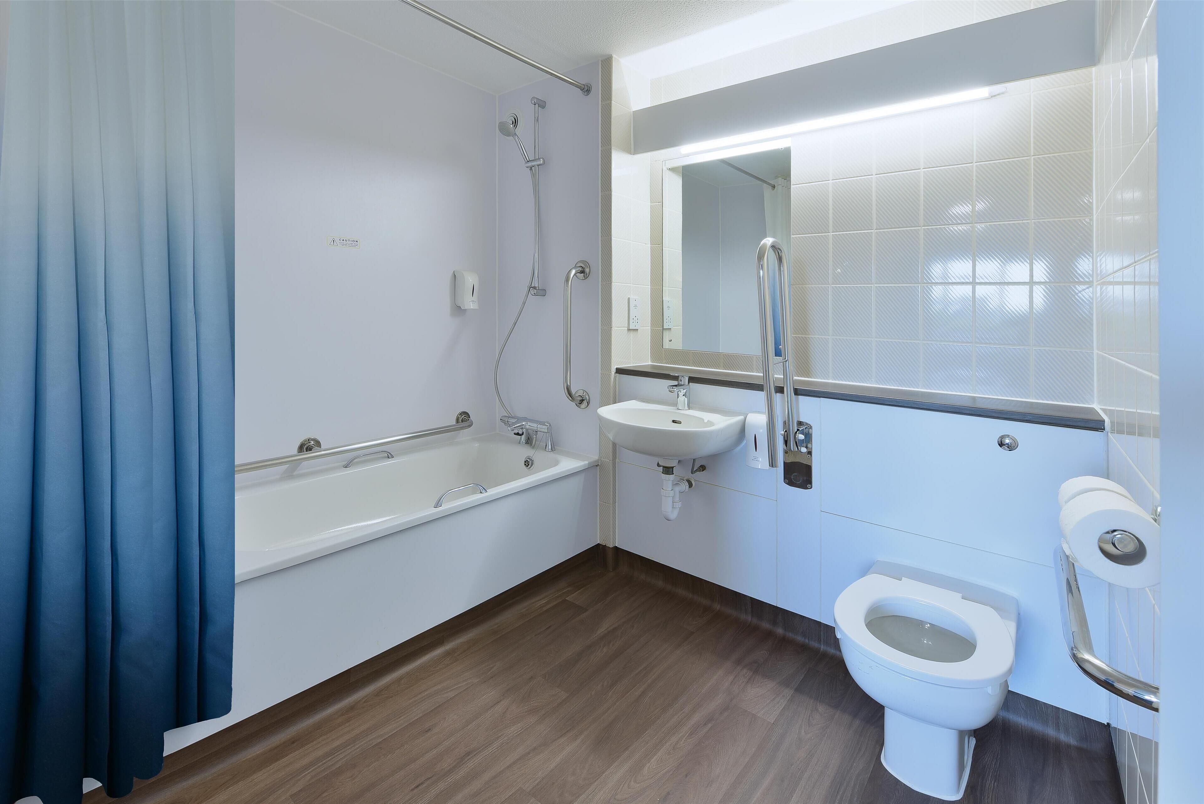A modern bathroom with a bathtub, a sink, and a toilet.
