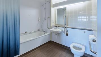 A modern bathroom with a bathtub, a sink, and a toilet.