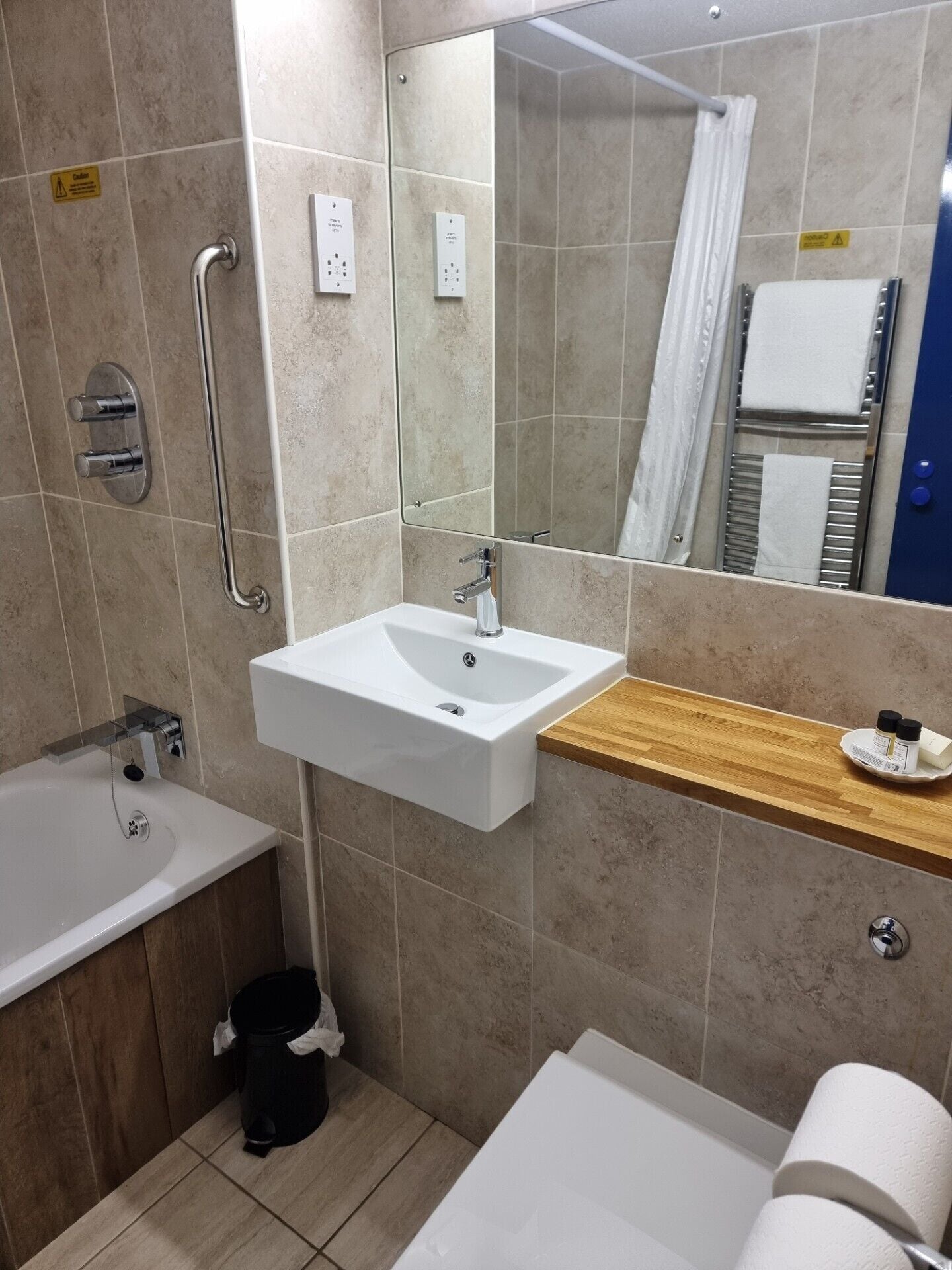 Une salle de bain moderne avec un lavabo blanc, une baignoire et une douche.