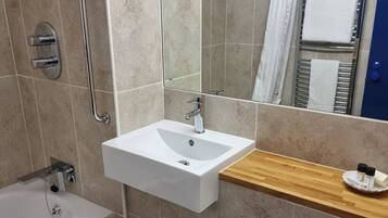 Une salle de bain moderne avec un lavabo blanc, une baignoire et une douche.