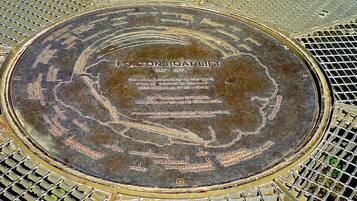 A commemorative plaque on a metal surface with engraved text and a map-like design.