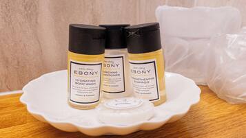 Three bottles of Ebony body wash and conditioner on a white plate.