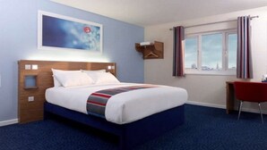 A hotel room with a bed, a desk, a chair, a window with curtains, and a painting on the wall. - Travelodge Nottingham Trowell M1 (Nottingham)