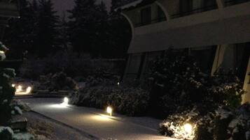 A snow-covered road with streetlights and a building with a curved facade.